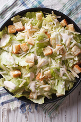Traditional Caesar salad closeup on a plate. vertical top view

