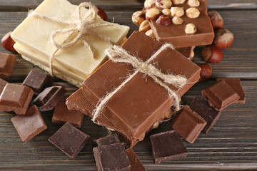 Set of chocolate with hazelnut on wooden table, closeup