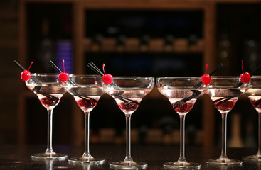 Glasses of cocktails on bar background