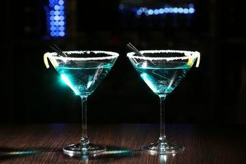 Glasses of cocktails on bar background