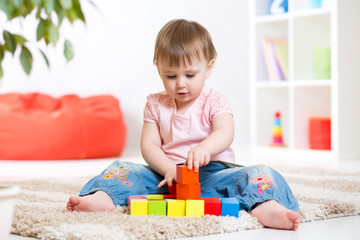 kid girl playing wooden block toys