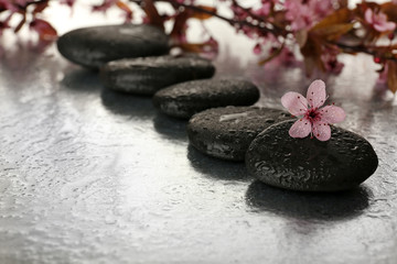 Spa stones with spring flowers on table close up