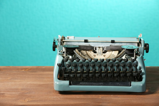 Old retro typewriter on table on green background