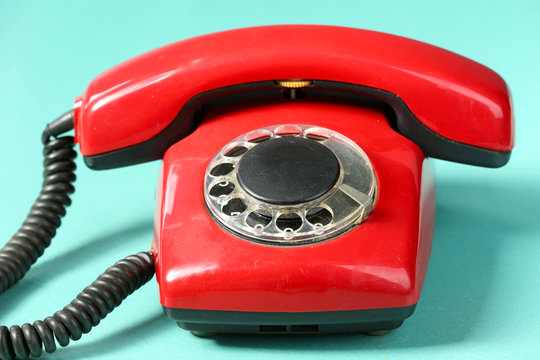 Retro red telephone on table on green background