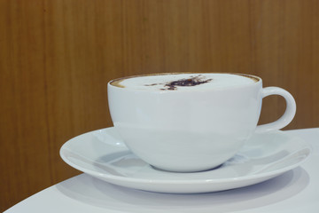 white cup cappuccino coffee on desk