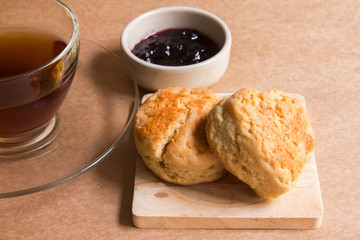 Scone with hot tea and blueberry jam.