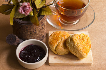 Scone with hot tea and blueberry jam.