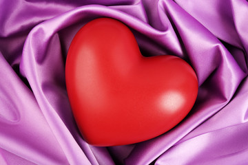 Red heart on fabric background