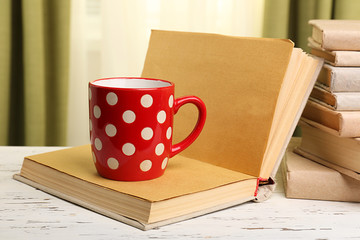 Books and cup on wooden table, closeup