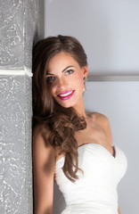 Obraz na płótnie Canvas beautiful bride in white wedding dress with hairstyle and makeup