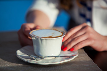 beautiful young girl in outdoor cafe reading a book and drinking