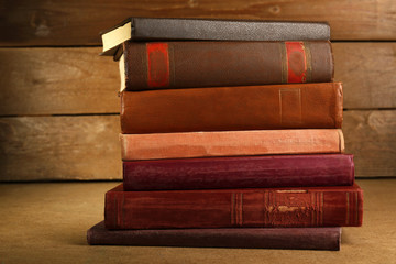 Old books on shelf, close-up, on wooden background