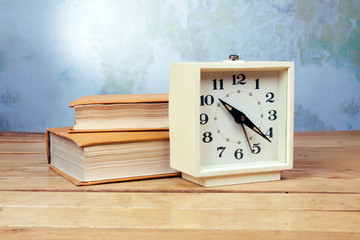 Old alarm clock with books