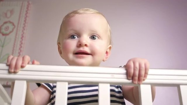 Baby standing in a crib