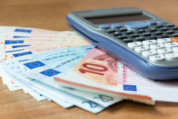 concept of savings analysis with banknotes and a calculator