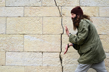 ein bärtiger Mann mit Riss in der Wand