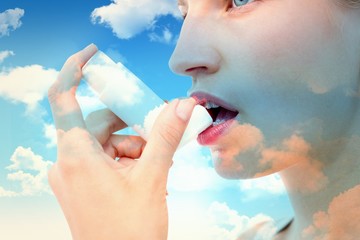 Composite image of blonde woman taking her inhaler