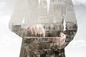 Obraz na płótnie Canvas Composite image of businessman using his tablet pc 