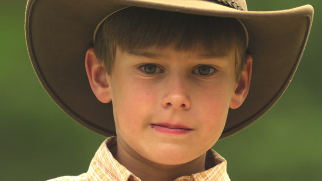 A close up of a boy in a cowboy hat
