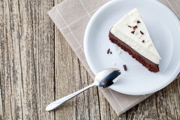 Vanilla cheesecake slice on wooden background.