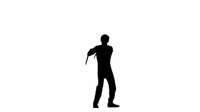 young man expertly twirling nunchaku, silhouette 