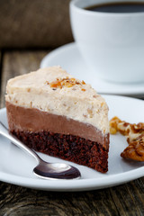 Tasty nuts cake with cup of coffee on wooden background.