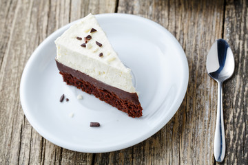 Vanilla cheesecake slice on wooden background.