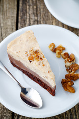 Tasty nuts cake with cup of coffee on wooden background.