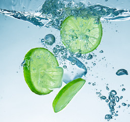 Limes splashing into water