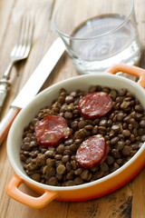 chorizo with lentil on dish on brown background