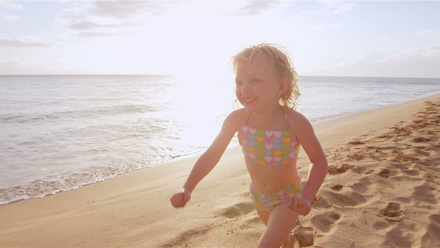 A little girl runs down the beach toward her mother for a big hug and kiss