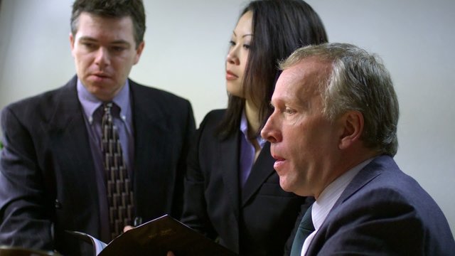 a group of office employees work together and the head honcho sips coffee