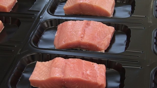 Vacuum packing red fish (trout, salmon, pink salmon). Seafood processing plant