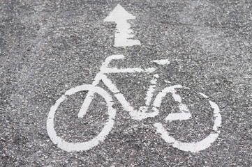 Strasse mit weissem Pfeil und Fahrradsymbol