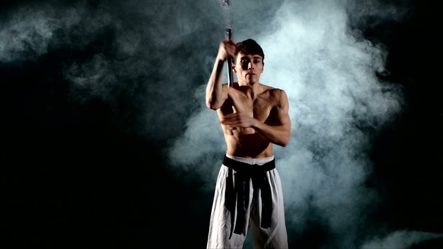 man  practicing karate or kung fu. Master holding nunchuck