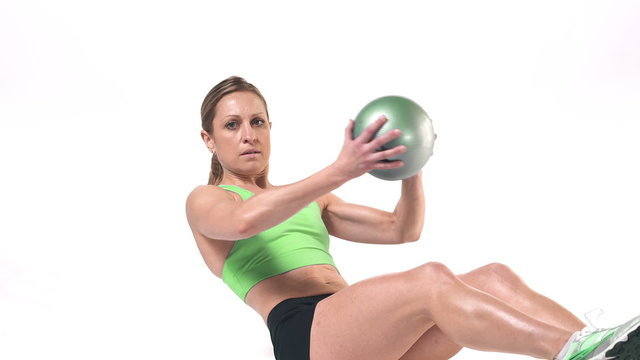 Wide shot of a female doing ab work outs with a medicine ball