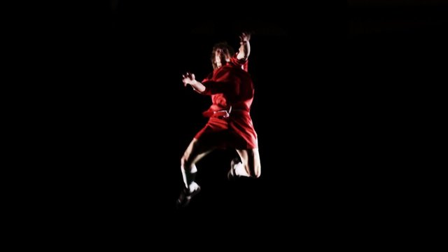A soccer player runs into frame and then kicks the ball off the screen
