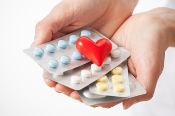 Hands holding many tablets and ceramic heart