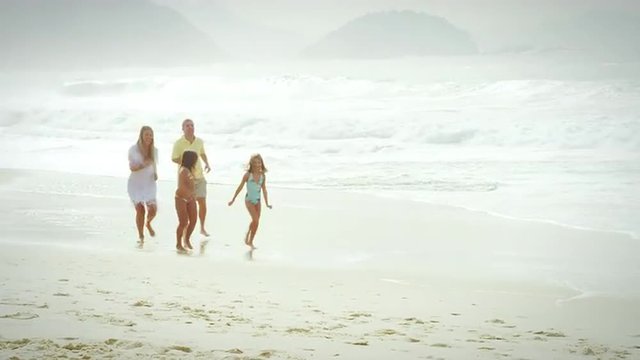 Brazilian family running down a beach in Brazil
