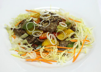 Delicious appetizer with meat served in a white plate.