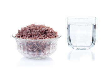 cooked riceberry and glass of water isolate one white background