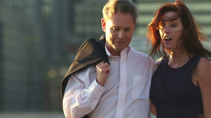 A man and woman couple walk together as they talk