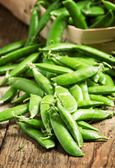 Young green peas on a wooden table, selective focus