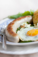 Bratwurst und Spiegelei auf Spinat und Karoffel