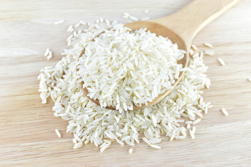 rice in wooden Spoon on rice and wooden background