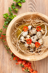 Quail eggs in a wooden bowl. top view