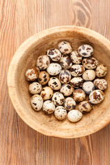 Quail eggs in rustic bowl. top view