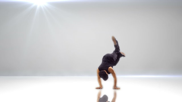 A break dancer pulls off his while colored yellow and with a colorful background