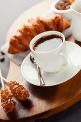 Fresh croissants  and cup of coffee on a table