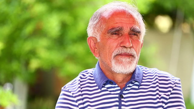 portrait of thinking senior man in a garden